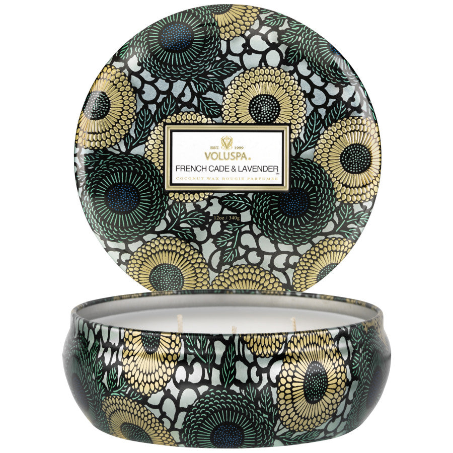 Decorative candle with floral pattern and Voluspa branding on a white background