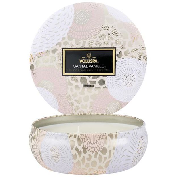 Decorative candle in a patterned container with Voluspa branding.