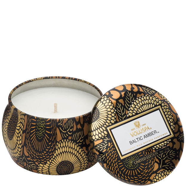 Decorative candle in a patterned container with 'Villosa' branding.