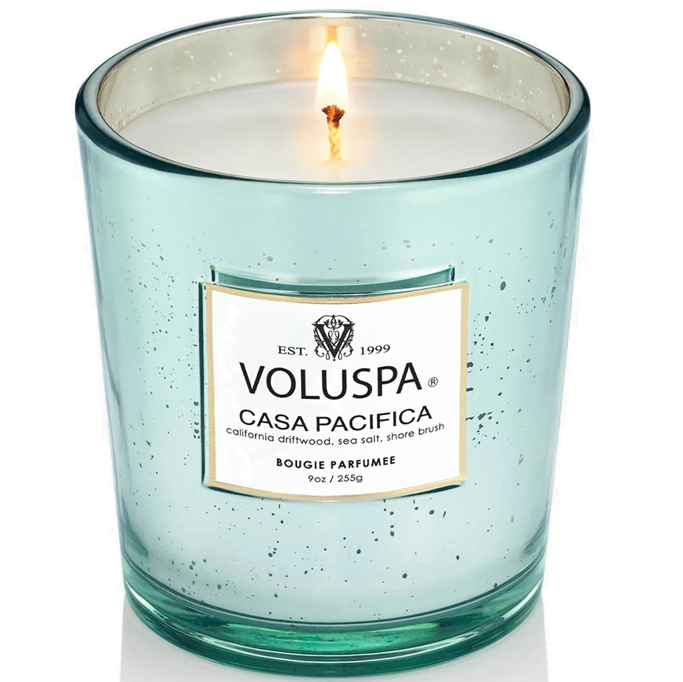 Lit Voluspa Casa Pacifica candle in a speckled glass container on a white background