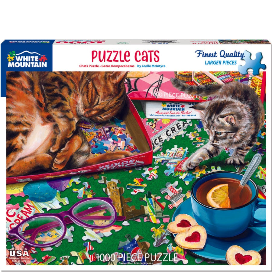 Puzzle box for 'Puzzle Cats' by White Mountain Puzzles with a cat-themed puzzle on a table.