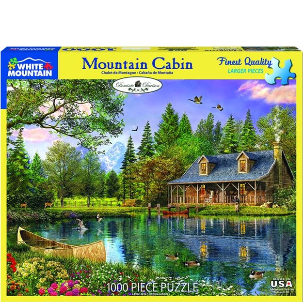 Jigsaw puzzle box featuring a mountain cabin scene with a lake and trees.