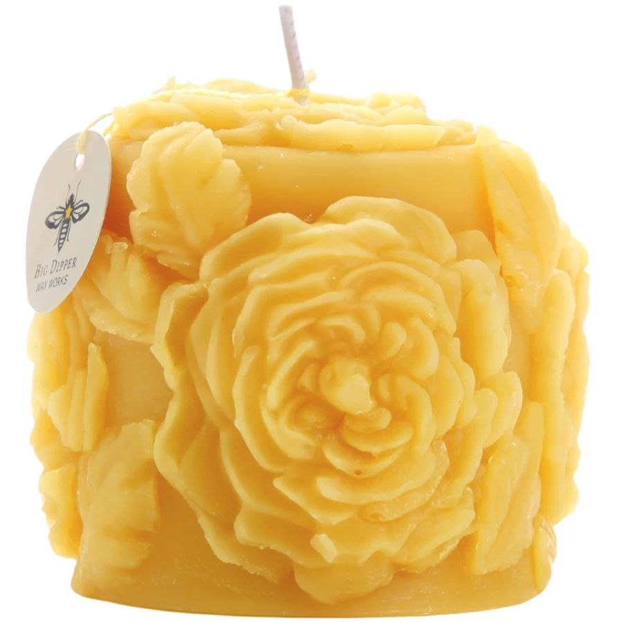 Yellow candle with floral designs on a white background