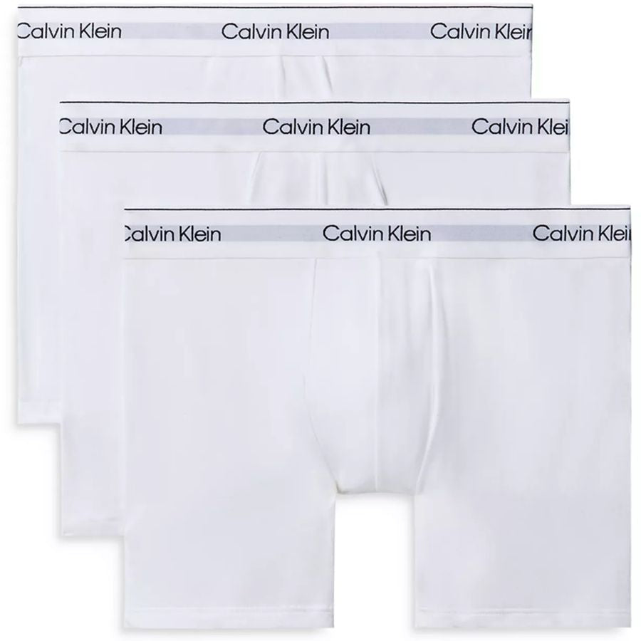Three pairs of Calvin Klein white boxer briefs arranged in a staggered stack, showing the brand name printed on the waistband.