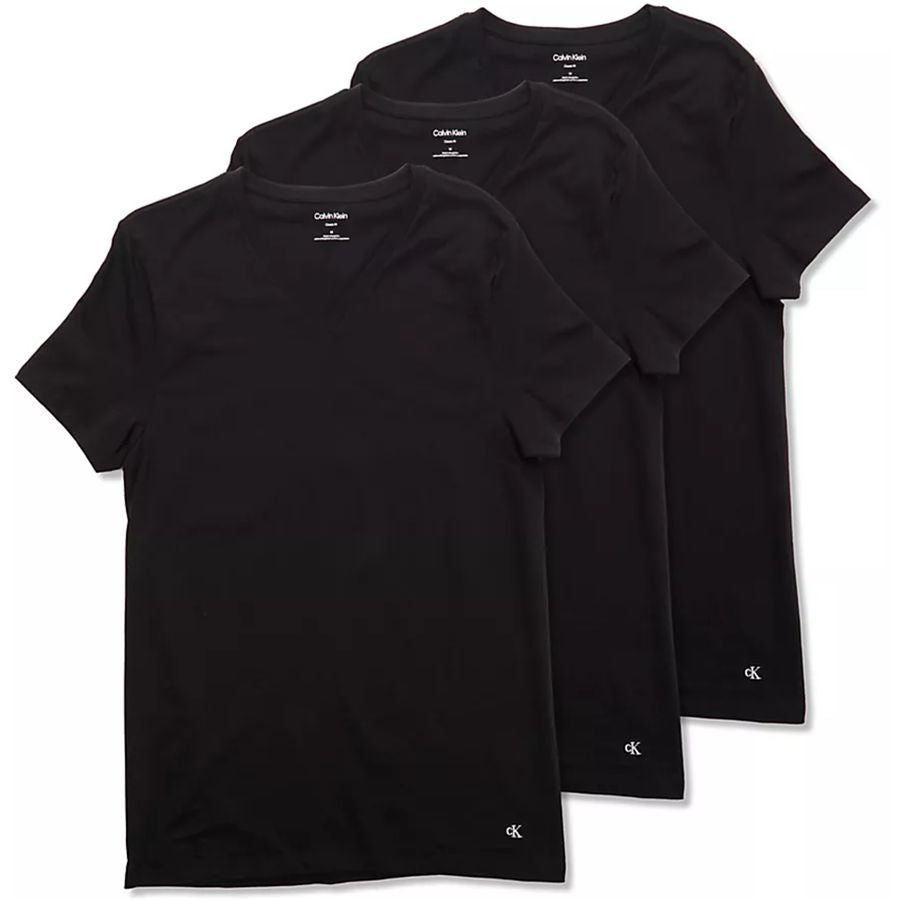 Three black short-sleeve crewneck t-shirts from Calvin Klein, arranged in a diagonal stack on a white background. Each shirt features a small white Calvin Klein logo printed near the bottom hem.