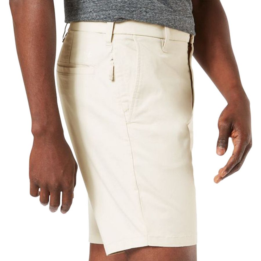 Beige shorts worn by a person on a white background