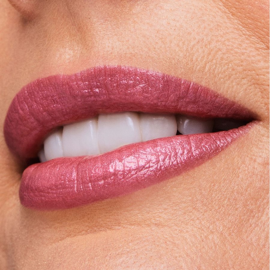 Close-up of a person's lips with pink lipstick on a beige background