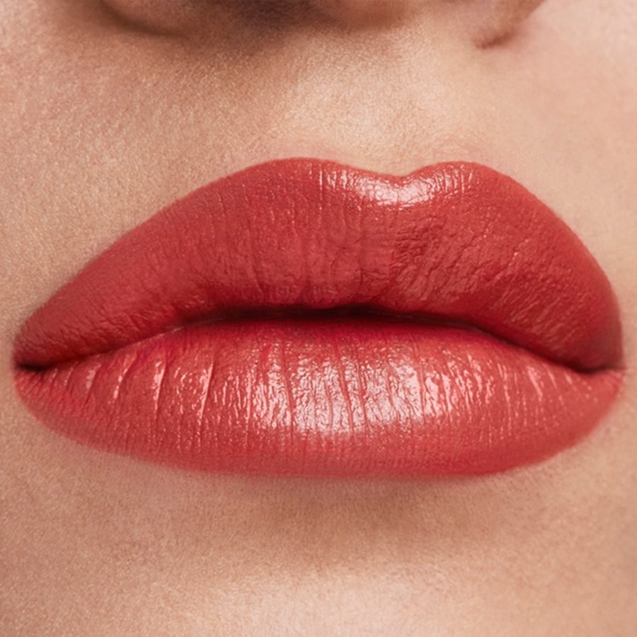 Close-up of a person's lips wearing a glossy red lipstick.