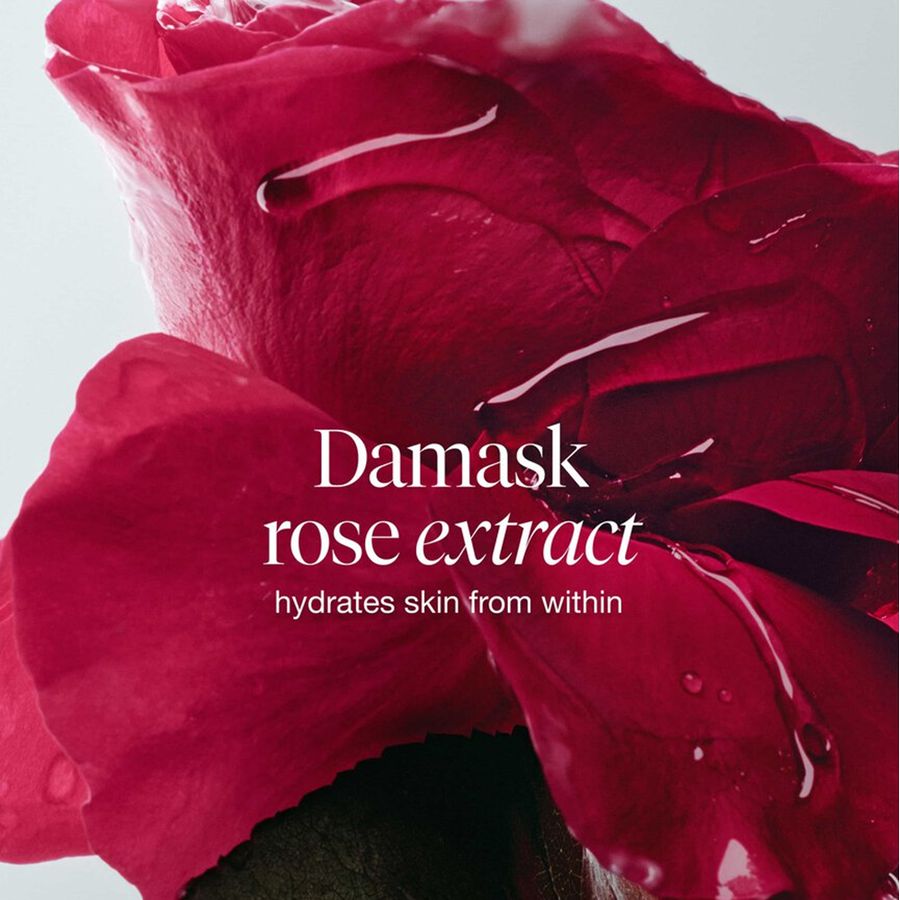A close-up of a deep red damask rose with glossy water droplets and white text reading 'Damask rose extract' and 'hydrates skin from within' on a light gray background.