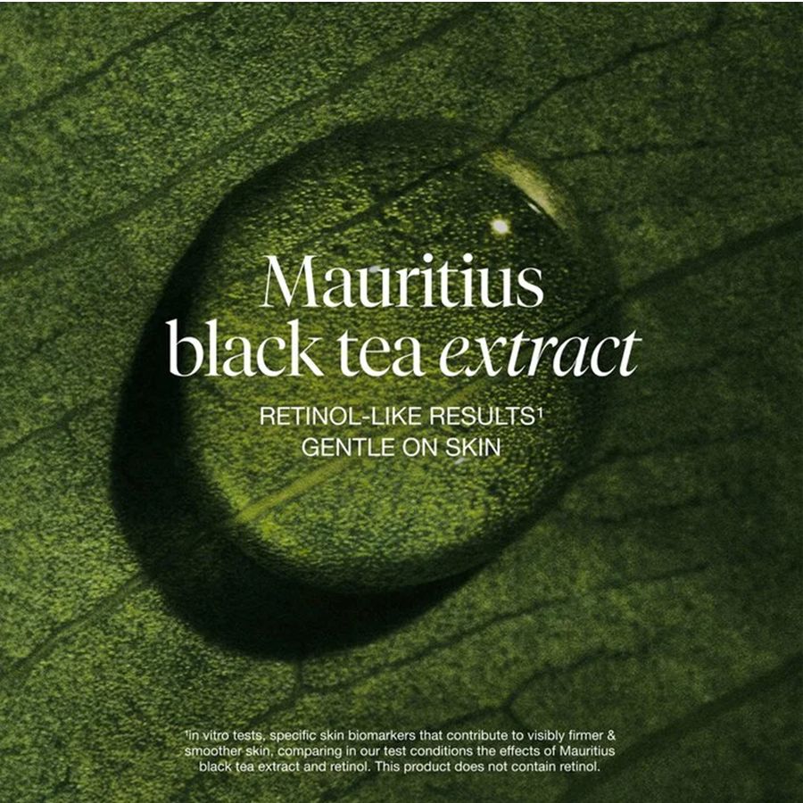 A close-up green leaf surface with a large water droplet in the center and white text reading 'Mauritius black tea extract' and 'RETINOL-LIKE RESULTS GENTLE ON SKIN'.