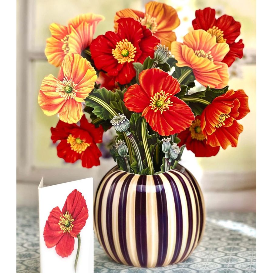 Striped vase with red and orange flowers on a patterned surface
