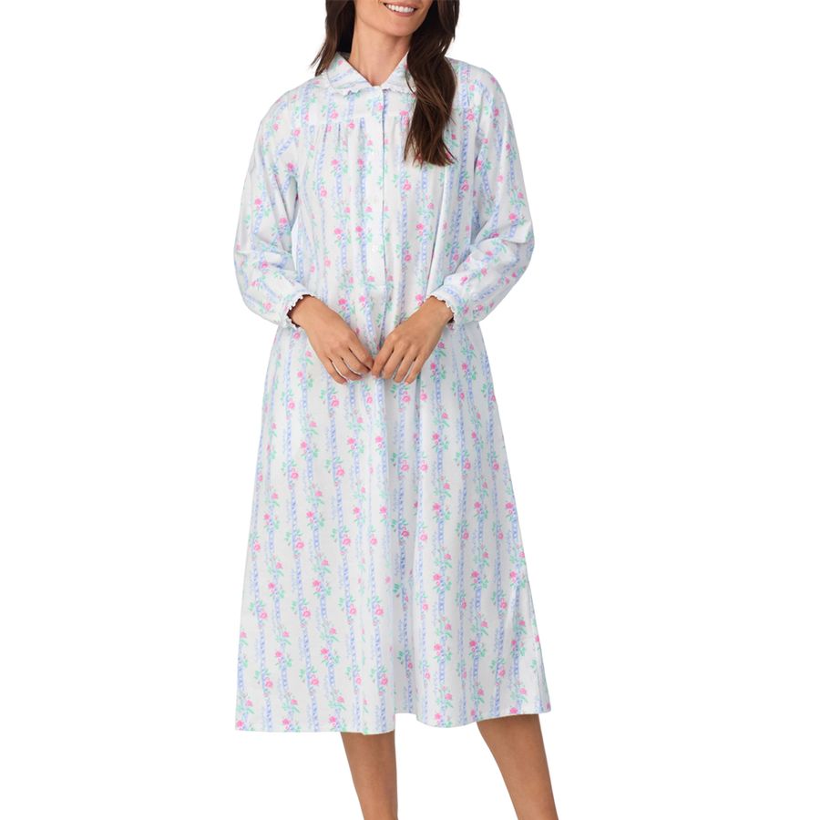 Woman wearing long-sleeved, floral-patterned nightdress with a collar and front closure, reaching mid-calf.