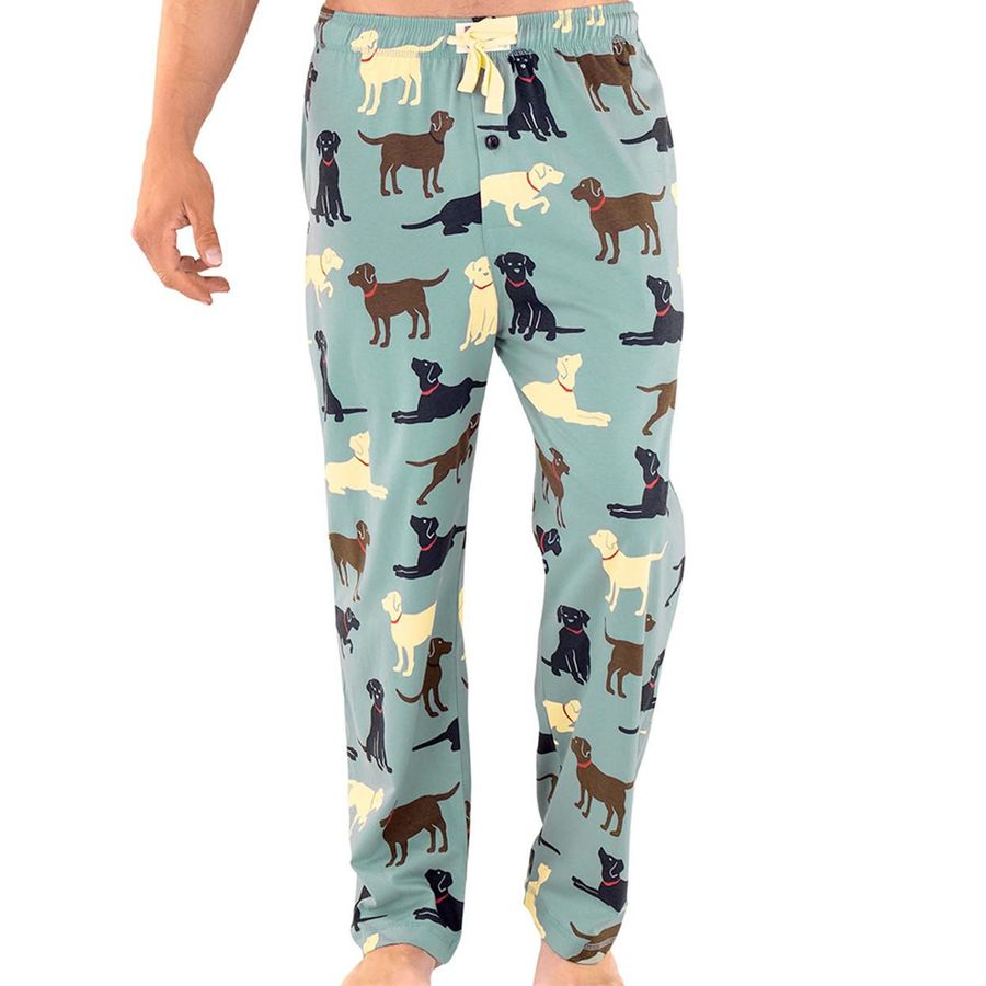 A person wearing light blue pajama pants covered in an all-over print of cartoon dogs in black, brown, cream, and tan, shown against a plain white background.