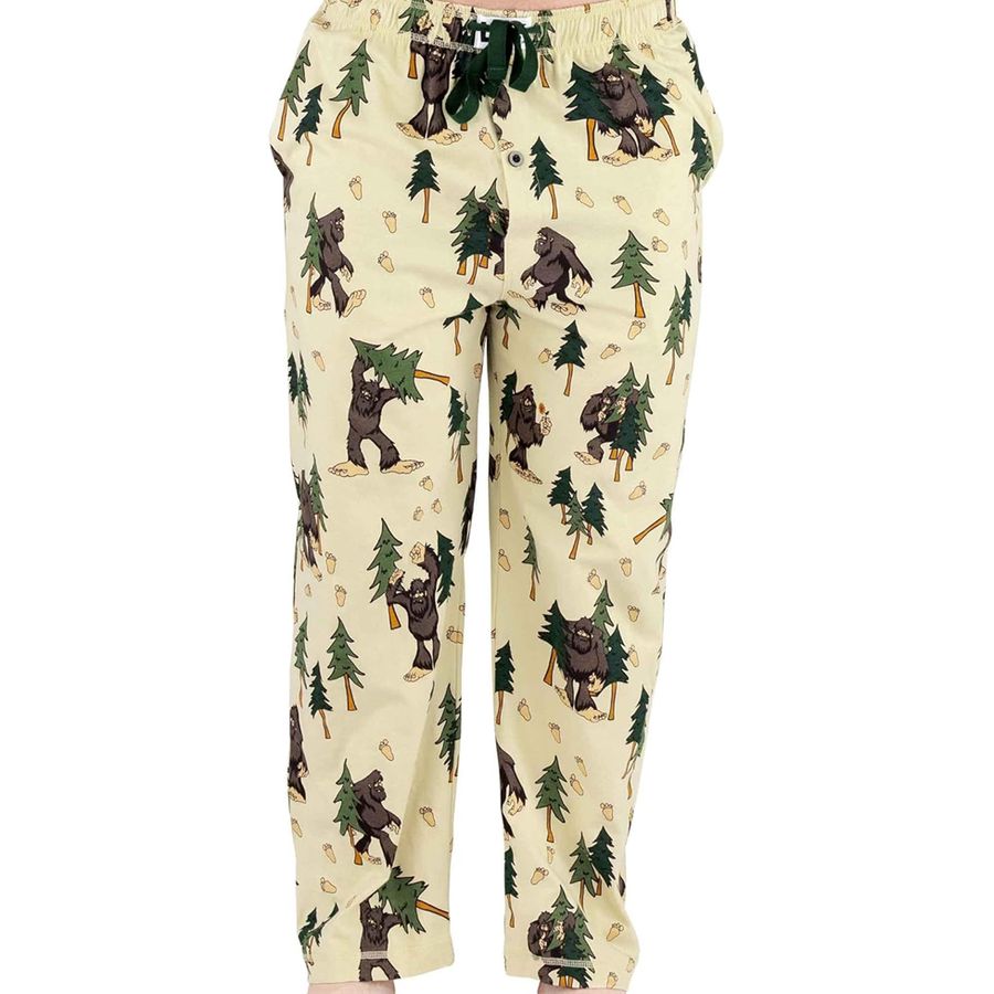 A pair of cream-colored pants featuring an all-over print of green pine trees and brown Bigfoot figures, shown against a plain white background.