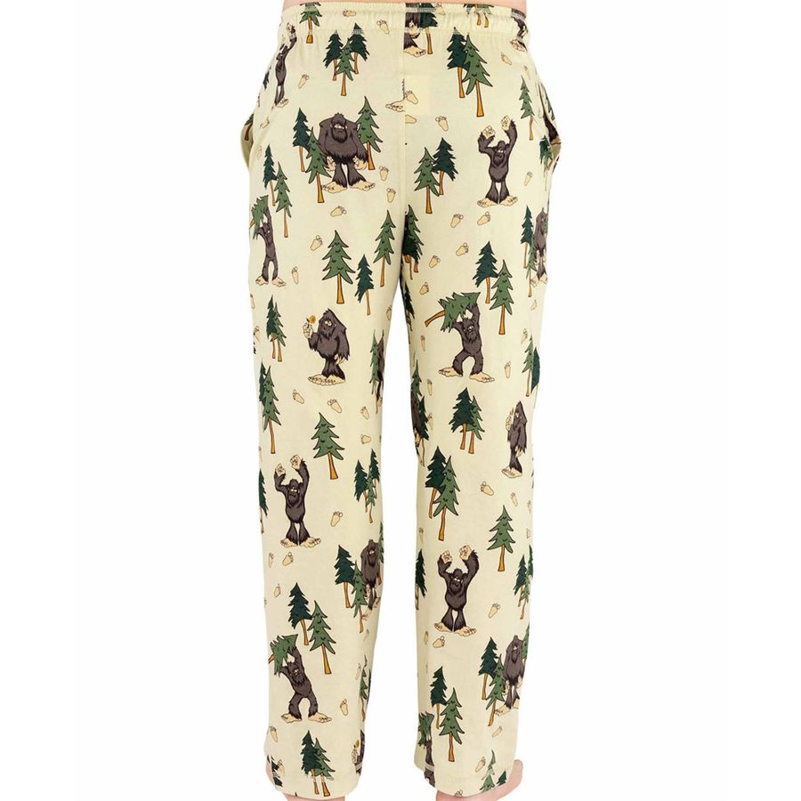 A pair of cream-colored pants featuring an all-over print of green pine trees and brown Bigfoot figures, shown against a plain white background.