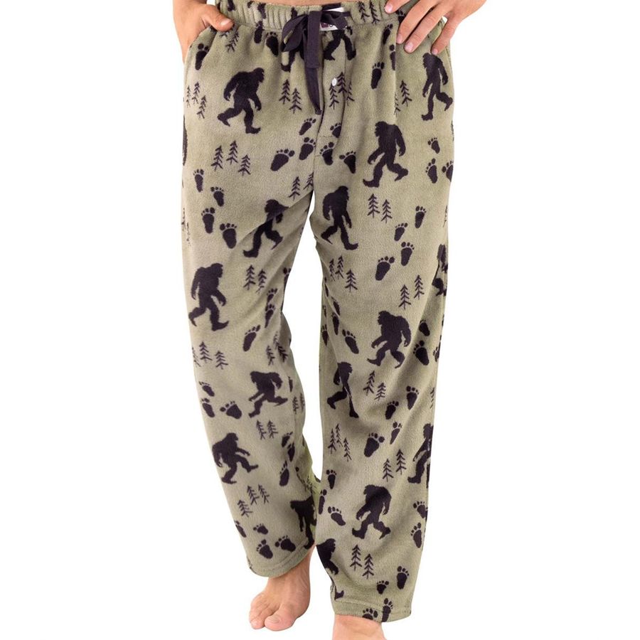 A pair of men's fleece lounge pants featuring a black Bigfoot and footprint pattern on a light khaki-beige background, modeled on a person against a white studio background.