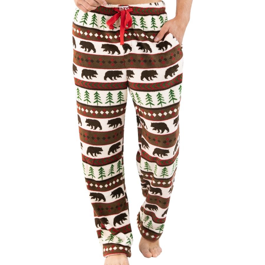 A person wearing fleece lounge pants with a brown, green, and cream holiday bear and tree pattern, featuring a red drawstring waistband.