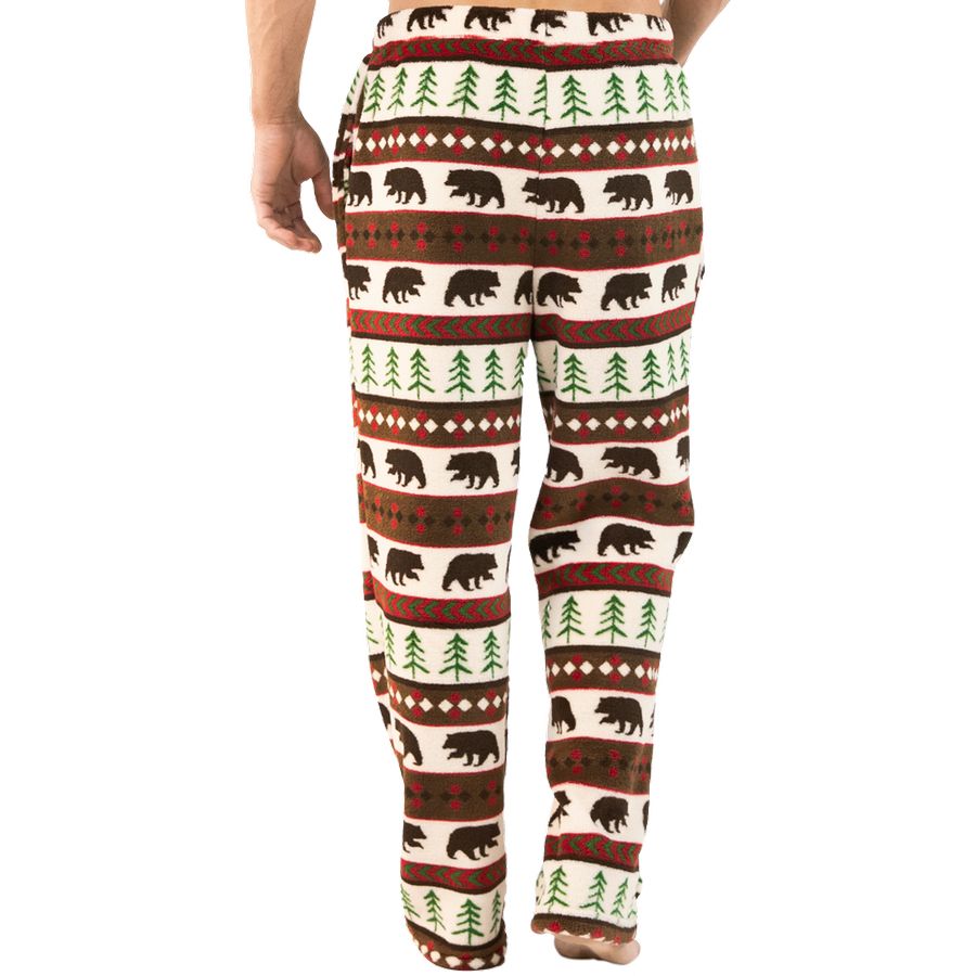 A person wearing fleece lounge pants with a brown, green, and cream holiday bear and tree pattern.