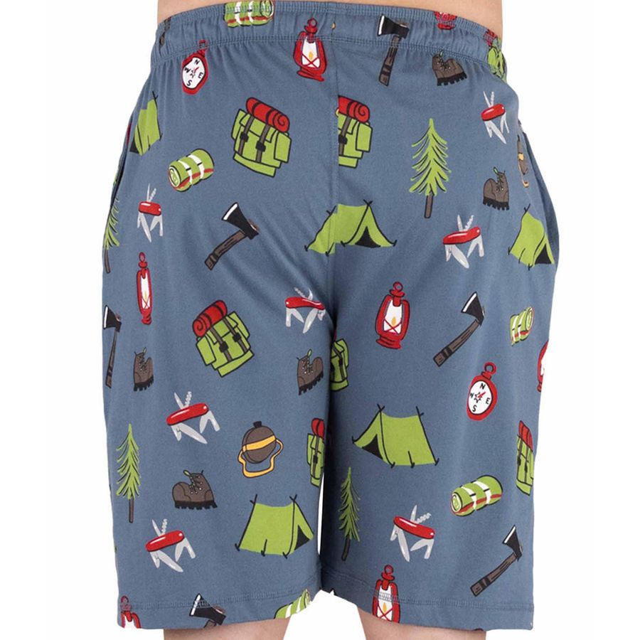 A pair of men's shorts featuring a blue-gray base color with a colorful camping-themed print of green tents, red lanterns, brown axes, and other outdoor gear, shown on a model against a white background.