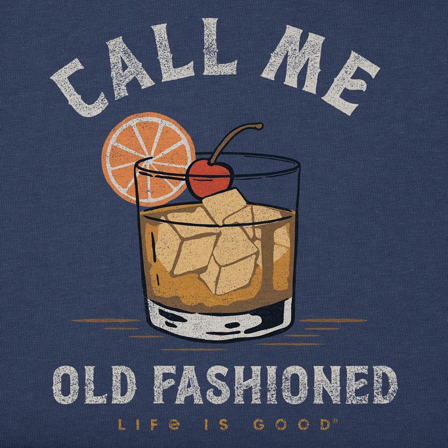 A navy blue graphic print featuring a retro-style illustration of an old fashioned cocktail with ice, a cherry, and an orange slice garnish. The text reads 'CALL ME OLD FASHIONED' in distressed white lettering, with 'LIFE IS GOOD' printed below.