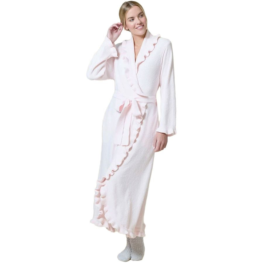 A woman modeling a long white bathrobe with light pink ruffle trim and a matching pink tie belt, shown against a plain white background.