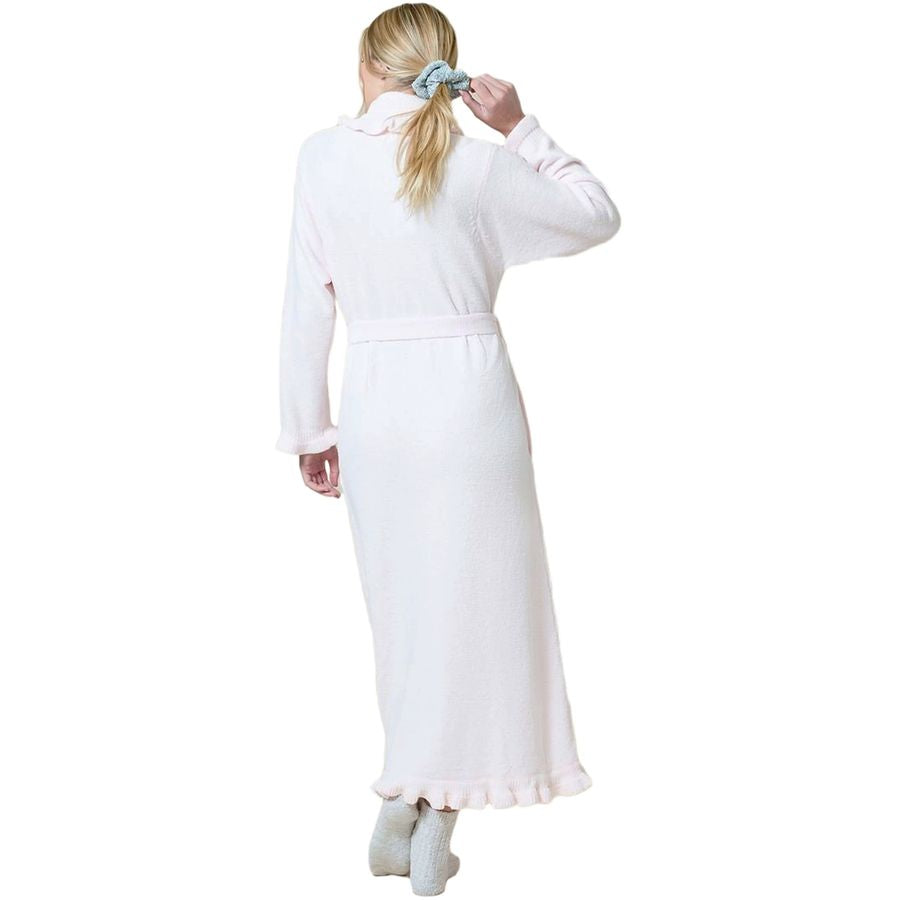 A woman viewed from the back wearing a long white robe with a matching waist tie and ruffled hem, standing against a plain white background.