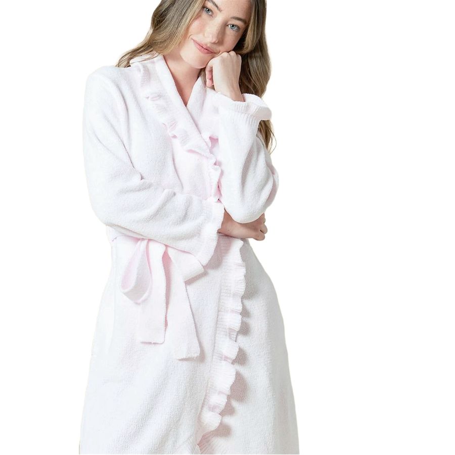 A woman wearing a plush white bathrobe with light pink ruffle trim and a matching tie belt, posed against a solid white background.