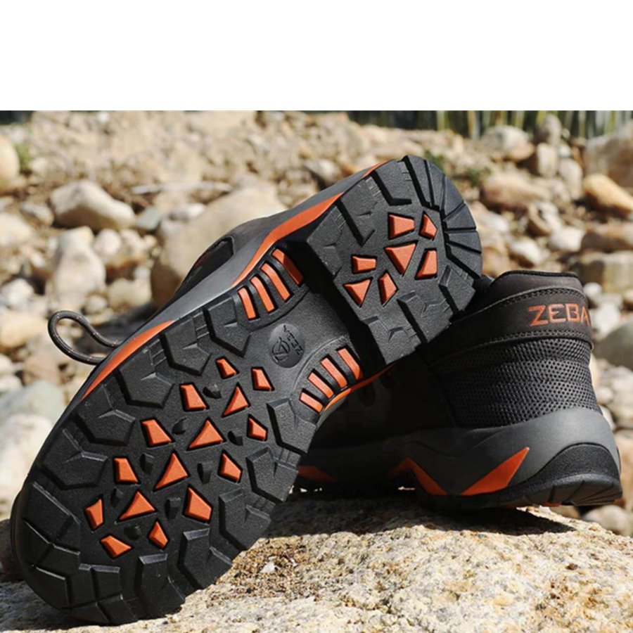 Black and orange hiking shoes on a rocky surface